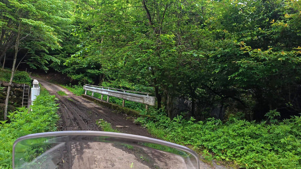 泥で滑りやすくなった橋と道路脇のガードレール
