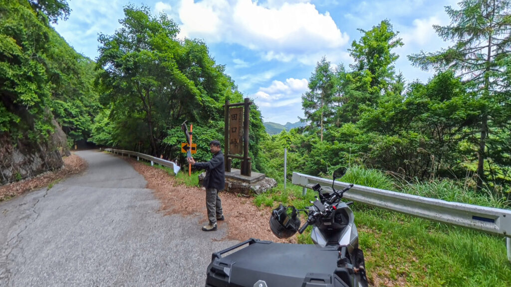 ADV160で田口峠に到着した様子。田口峠の標識と山深い峠道