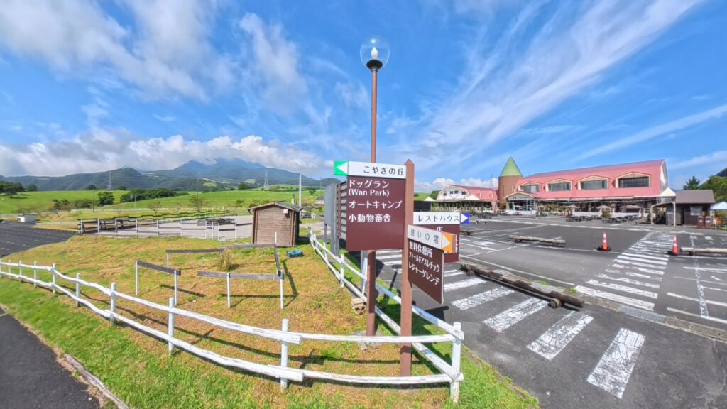 青空の下に緑の牧草地と山並みが広がる大笹牧場