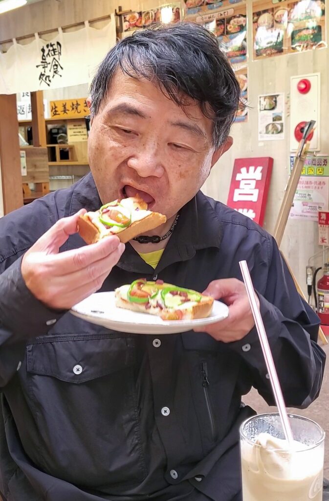 道の駅しもにたの食事処でピザトーストを食べながら休憩する様子