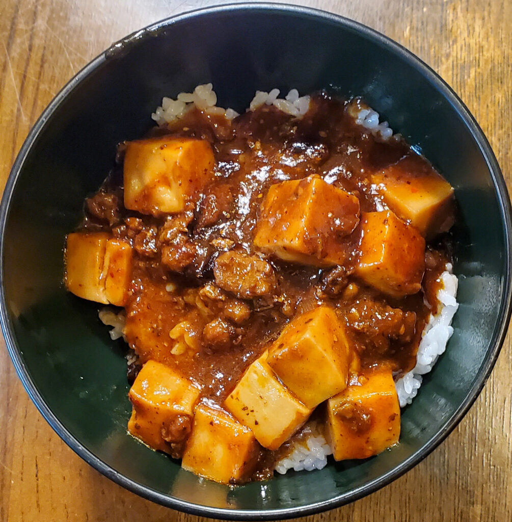 松屋の四川風麻婆豆腐をご飯にかけた麻婆丼。大きめの豆腐とひき肉がたっぷり入っている。
