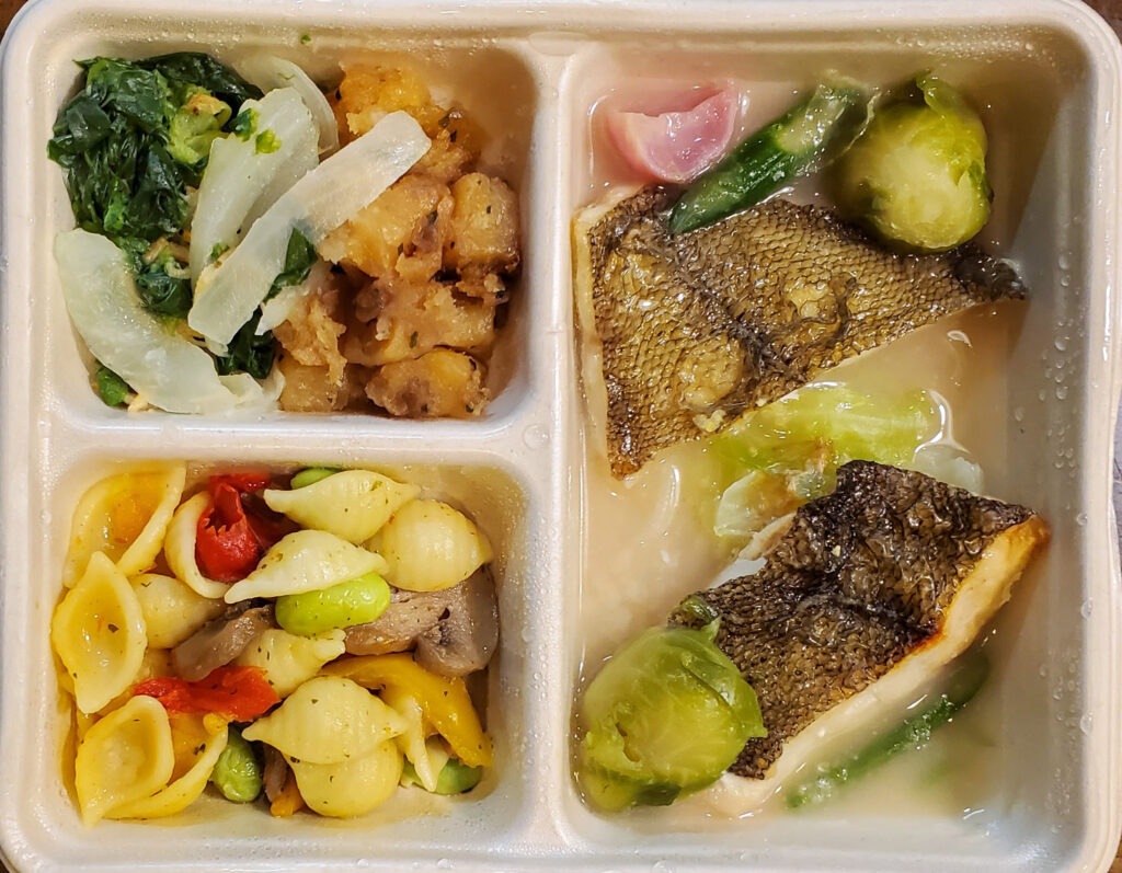 DELIPICKSの白身魚のオーブン焼き。アンチョビバターソースをかけた黄金ガレイと芽キャベツ、アスパラガス、パスタなどの副菜。