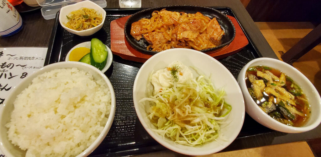 小山市のごはんや天神で注文したスタミナ焼肉定食。鉄板焼肉、ご飯、サラダ、汁物、小鉢、漬物が並ぶ。