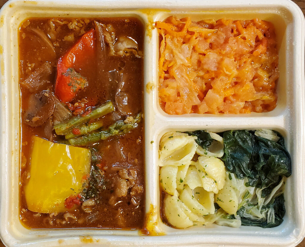 DELIPICKSのビーフストロガノフ。牛肉やパプリカ、アスパラガスが入った赤茶色の煮込み料理と、野菜を使った2種類の副菜。