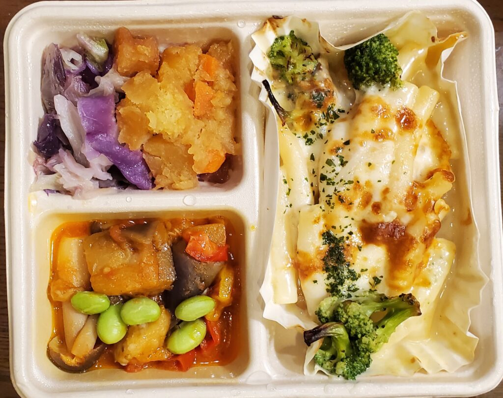 DELIPICKSのシーフードグラタン。チーズとブロッコリーをのせたグラタンに、野菜のトマトバター和えなど2種類の副菜が添えられている。