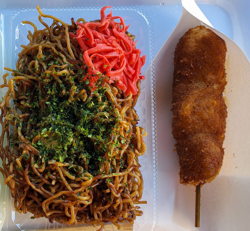 江原商店で購入した佐野名物いもフライと焼きそば。こんがり揚がった串刺しのいもフライと、青のりや紅しょうがを添えた焼きそば。