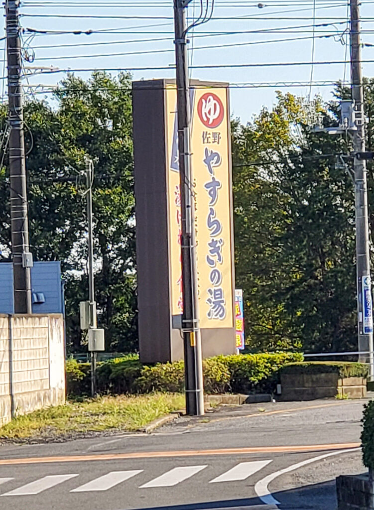 道路沿いに立つ佐野やすらぎの湯の大きな案内看板