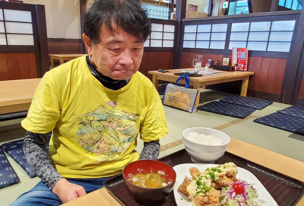 佐野やすらぎの湯の食事処で鶏からタルタル定食を前に座るShin