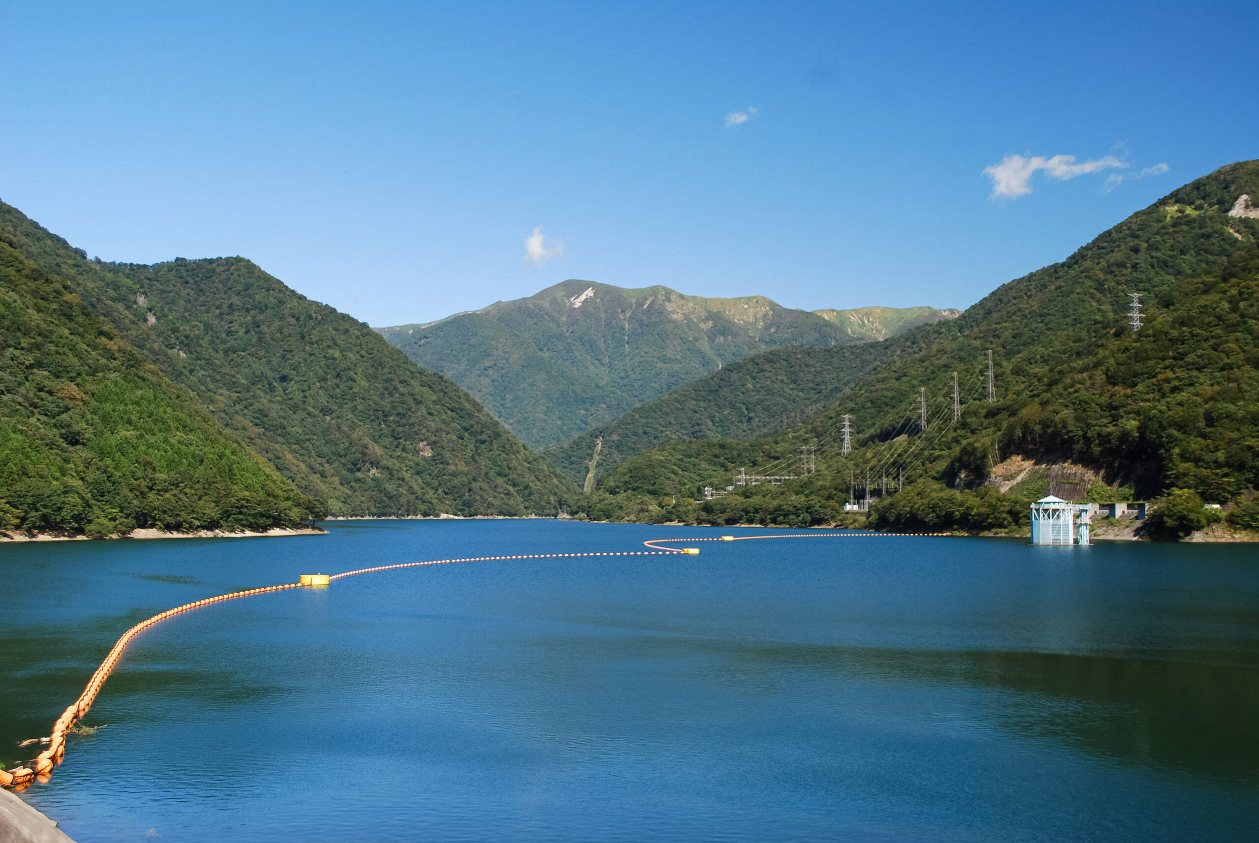 栃木県那須塩原市の深山湖。緑豊かな山々に囲まれた青い湖面と、遠方の山並みが広がる風景。