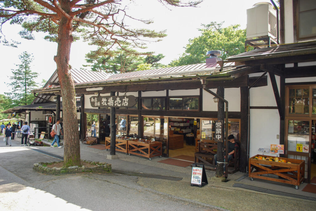 那須高原の南ヶ丘牧場にある牧場売店。木造の建物と売店前を歩く観光客。