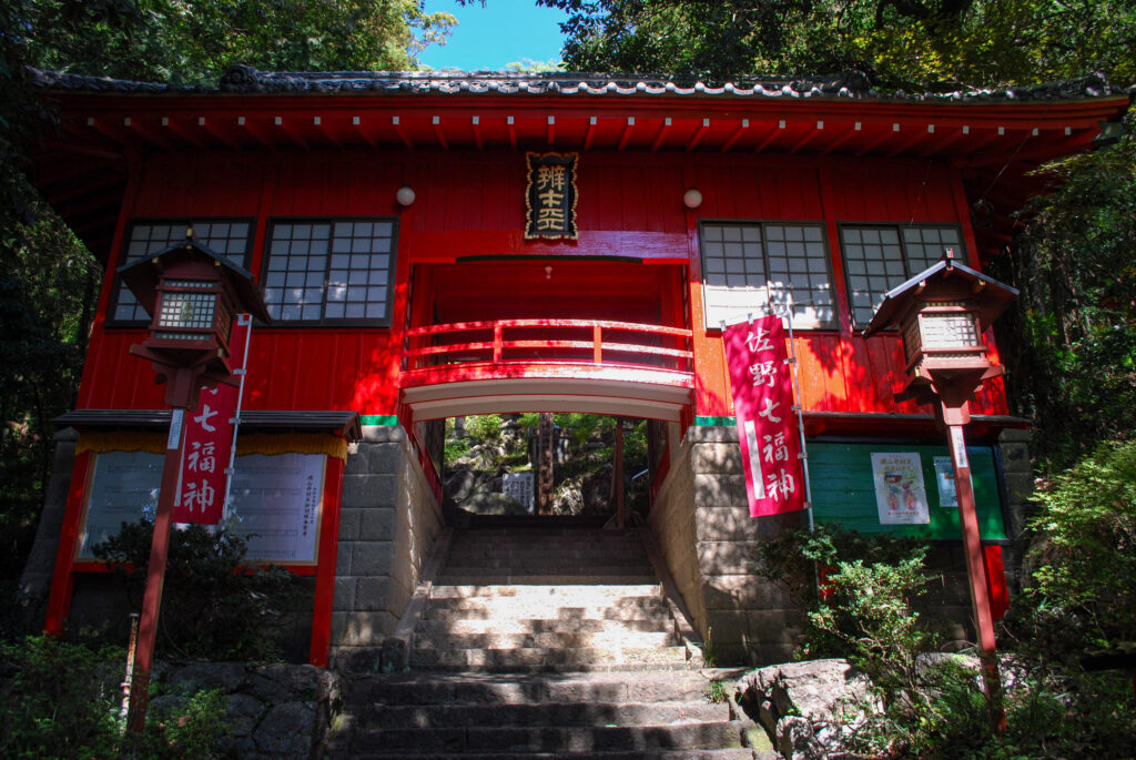 磯山弁財天の朱塗りの楼門。石段の上に鮮やかな赤い建物が建つ。